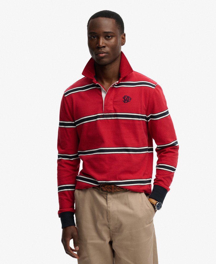 Man wearing a red striped polo shirt with a logo on a white background