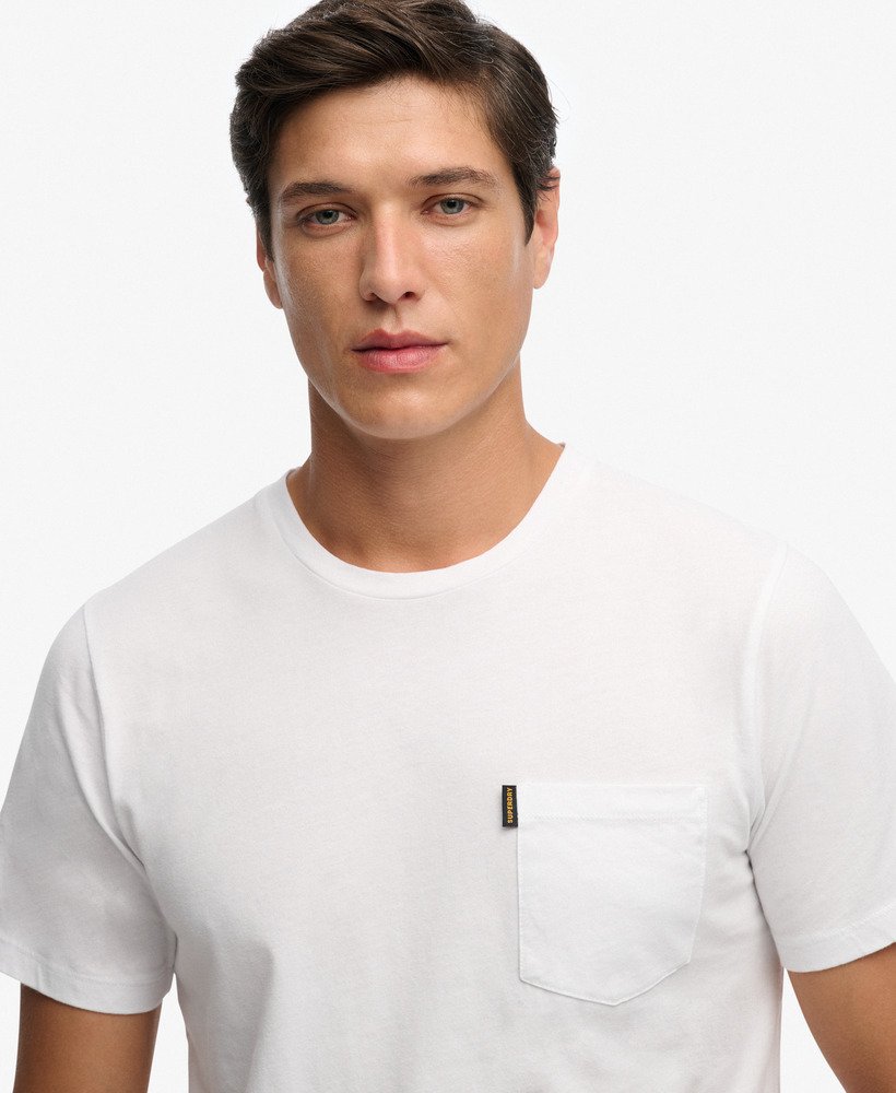Man wearing a white t-shirt with a small logo on a white background