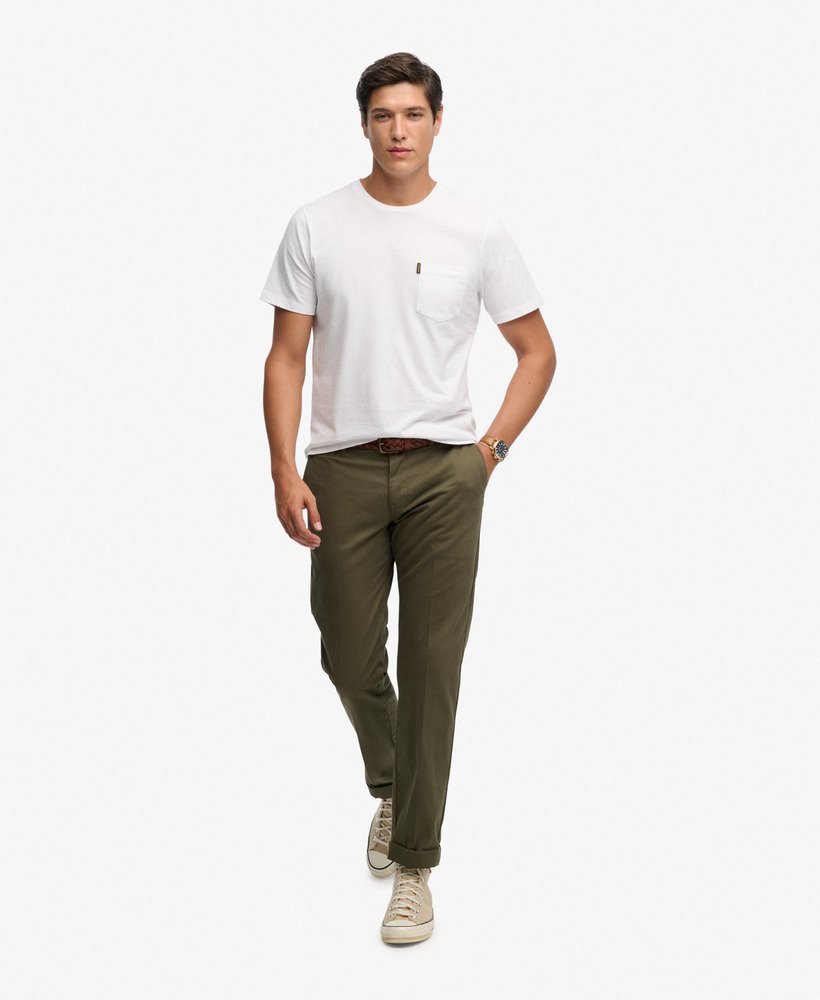 Man wearing a plain white t-shirt with khaki trousers on a white background