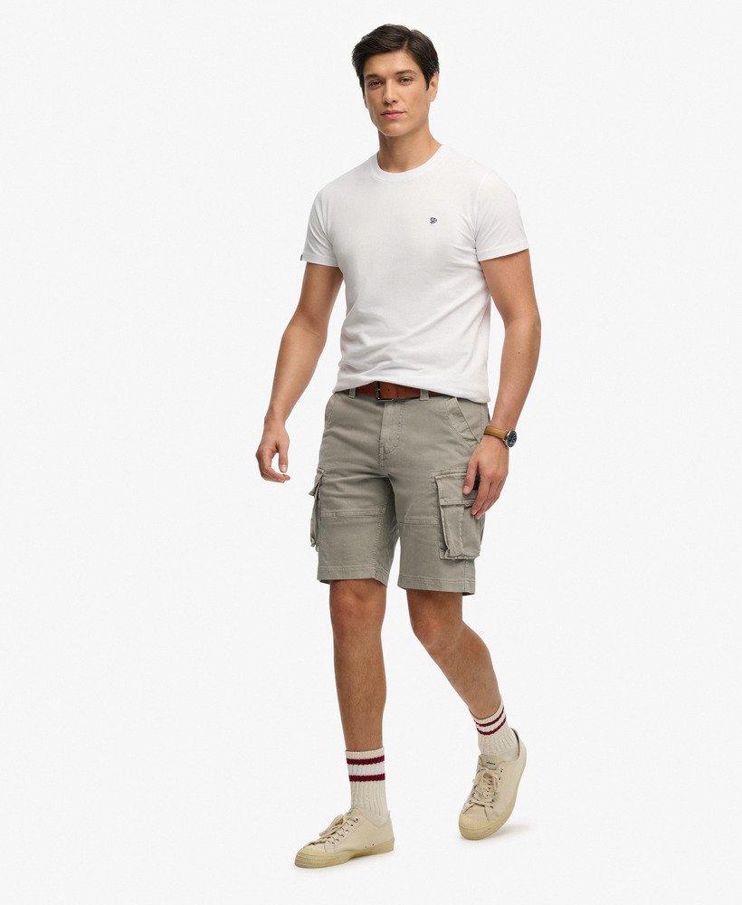 Man wearing a white t-shirt and beige cargo shorts on a white background