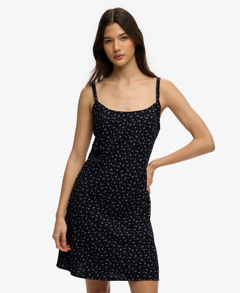 Woman wearing a black dress with white patterns on a white background