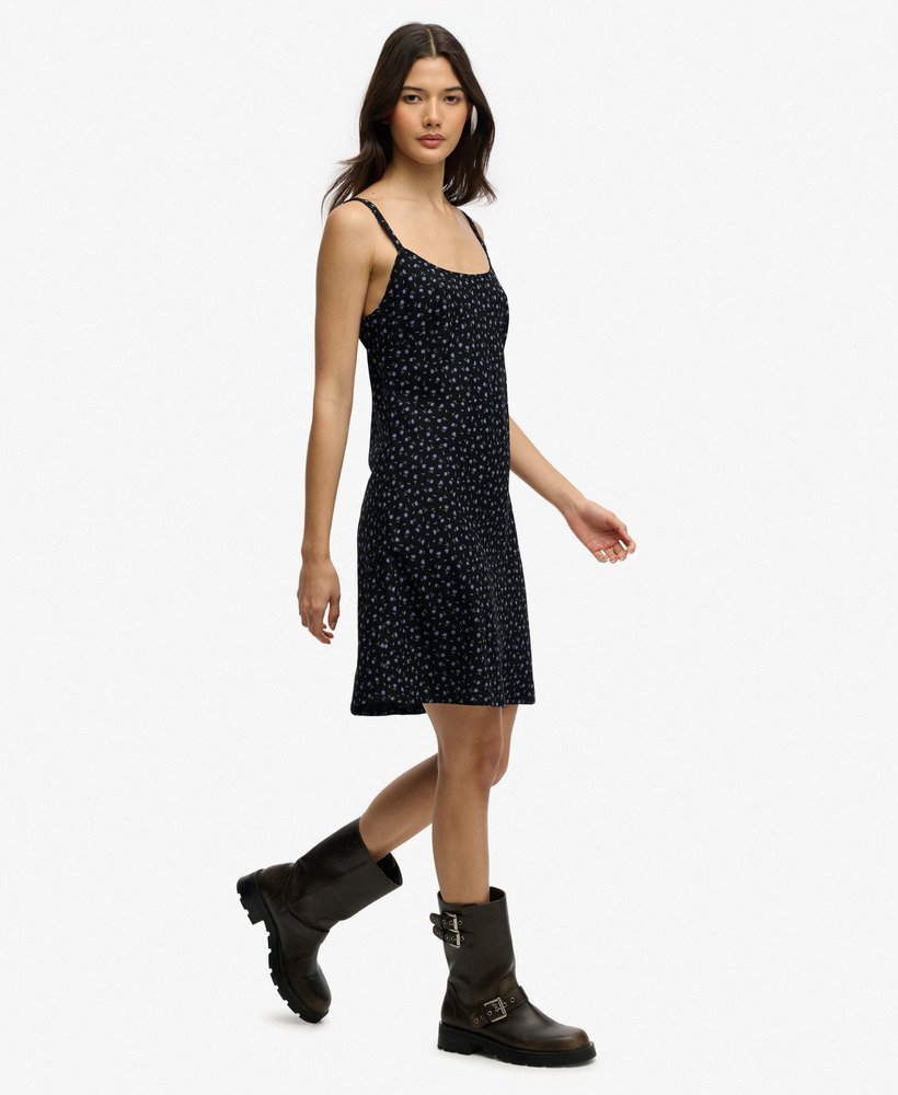 Woman wearing a black dress with white patterns on a white background