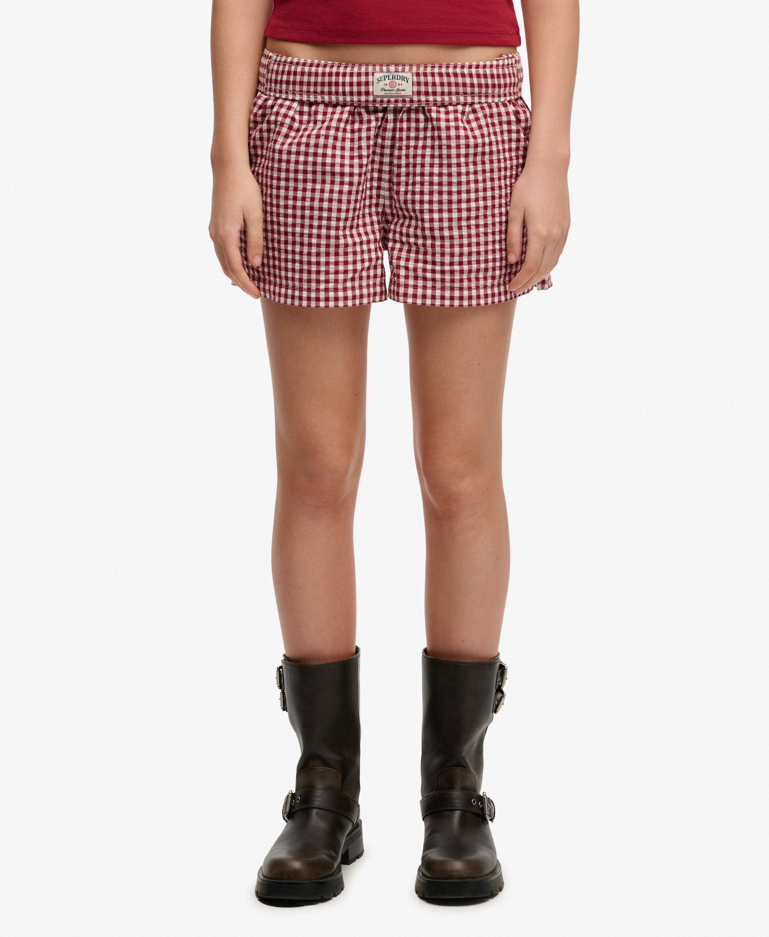Person wearing red and white checkered shorts on a white background
