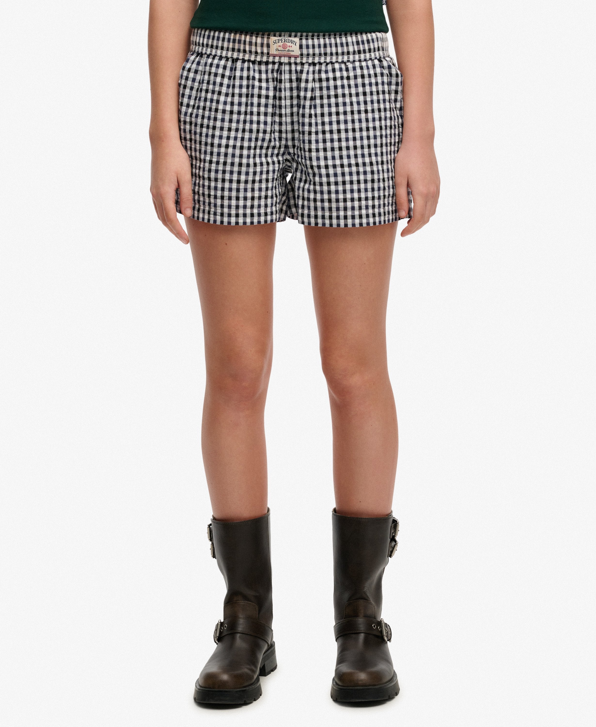 Person wearing black and white checkered shorts on a white background