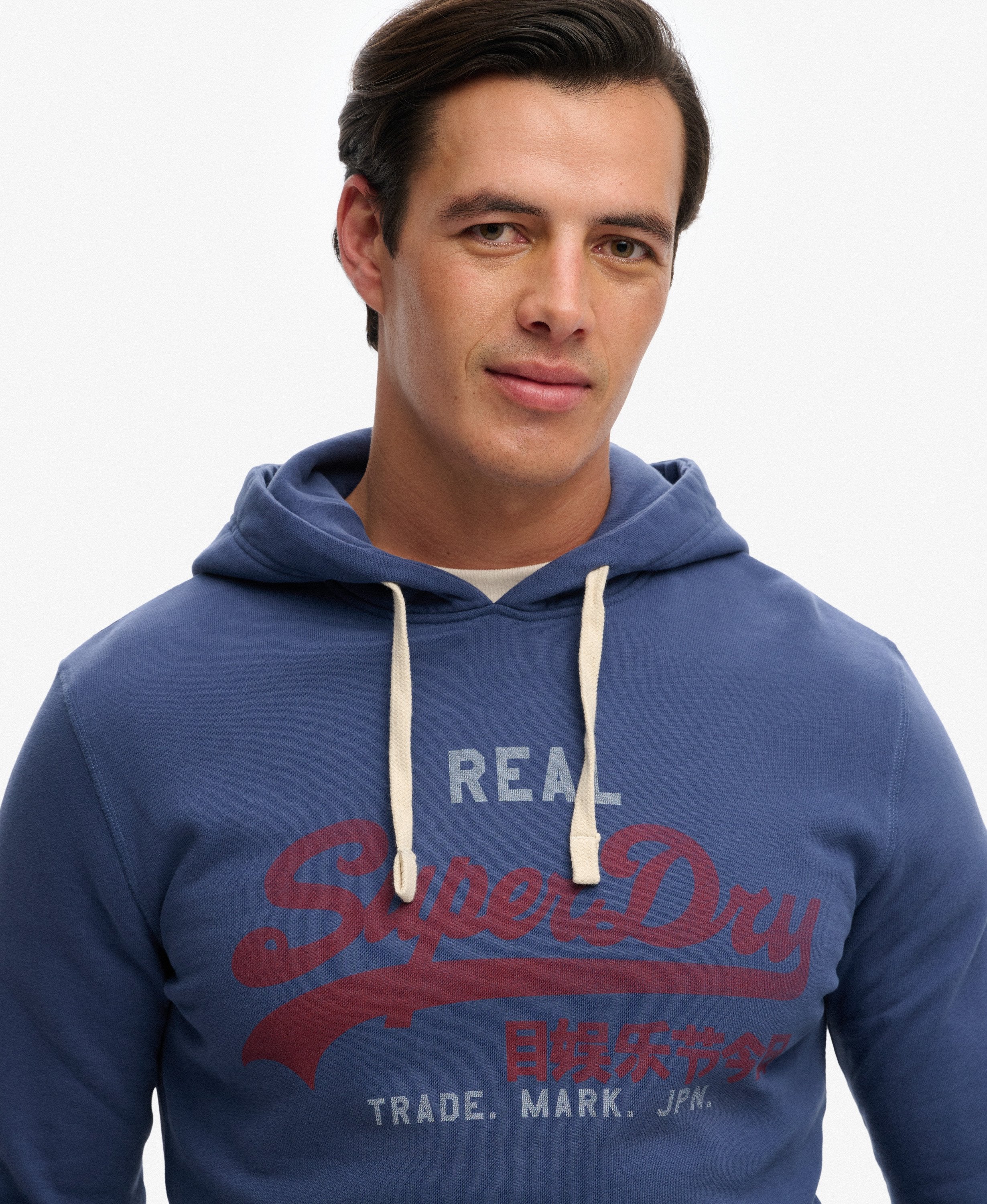 Man wearing a blue SuperDry hoodie on a white background