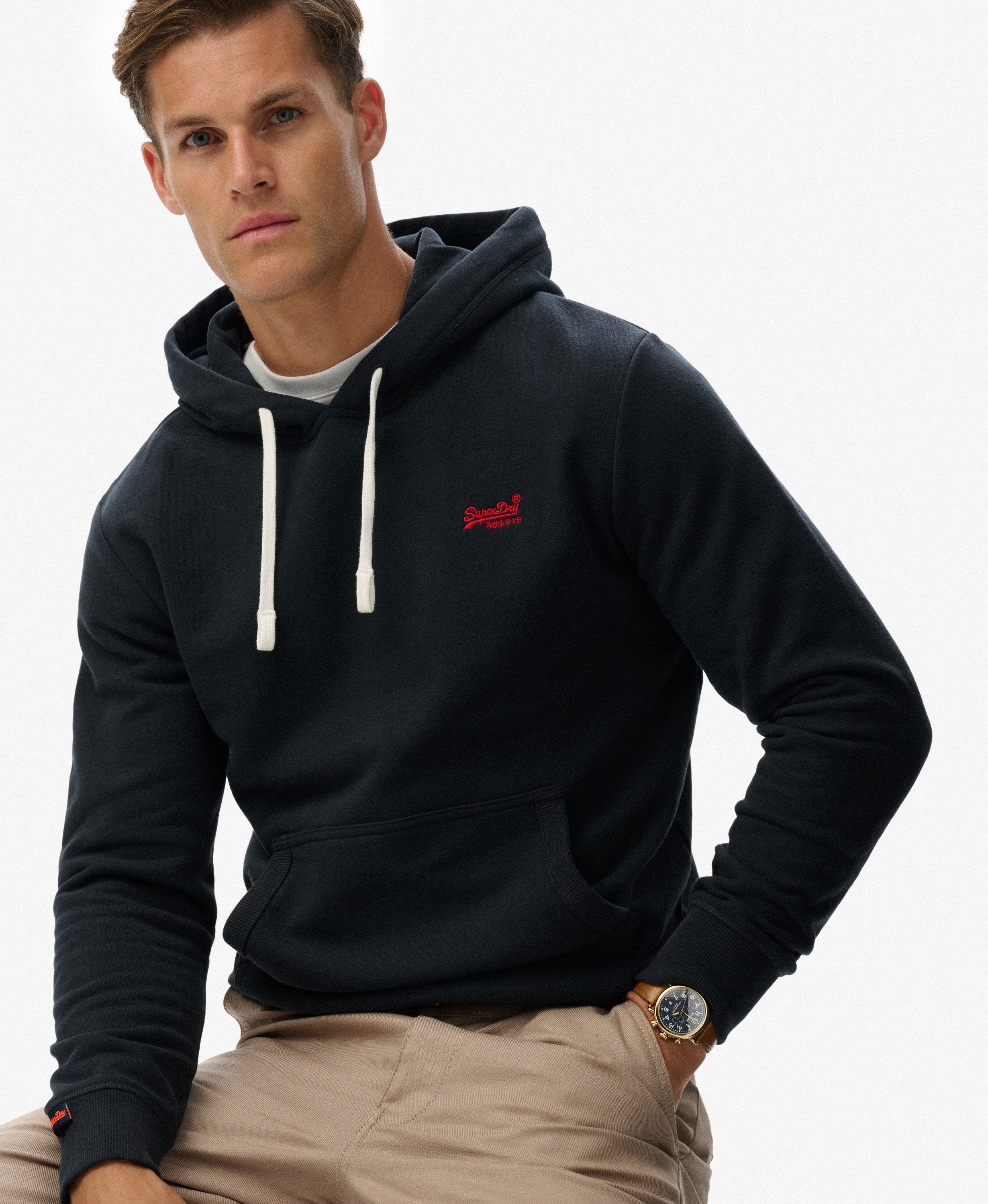 Man wearing a black hoodie with a red logo on a white background